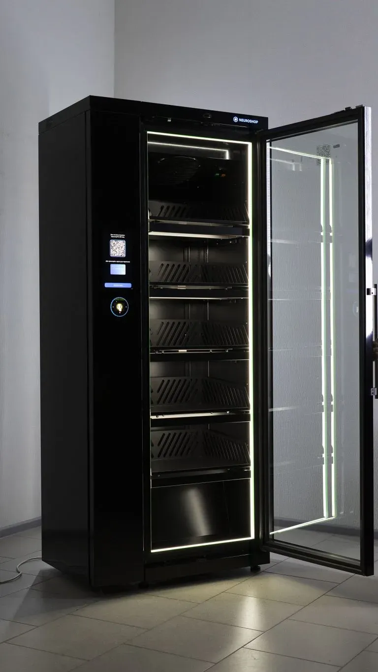 Black cabinet with the glass door open and empty lit shelves